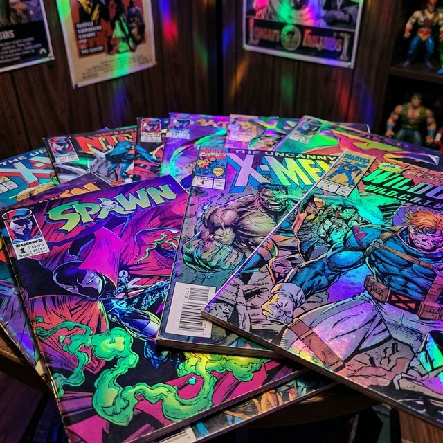 A collection of 1990s comic books with vibrant holographic and metallic covers.